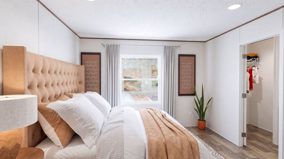 Factory photo of a furnished primary bedroom with walk-in closet