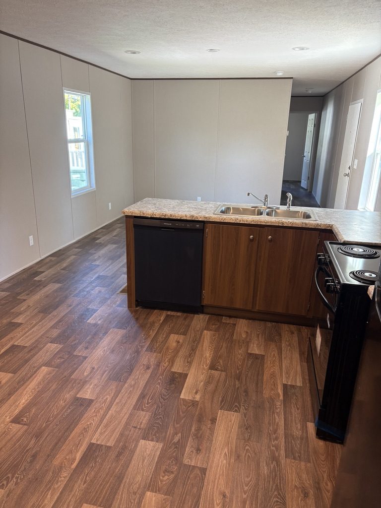 Open kitchen and living area with a peninsula and wood-look flooring